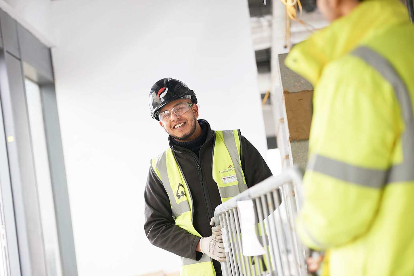 2 people on site moving a railing 