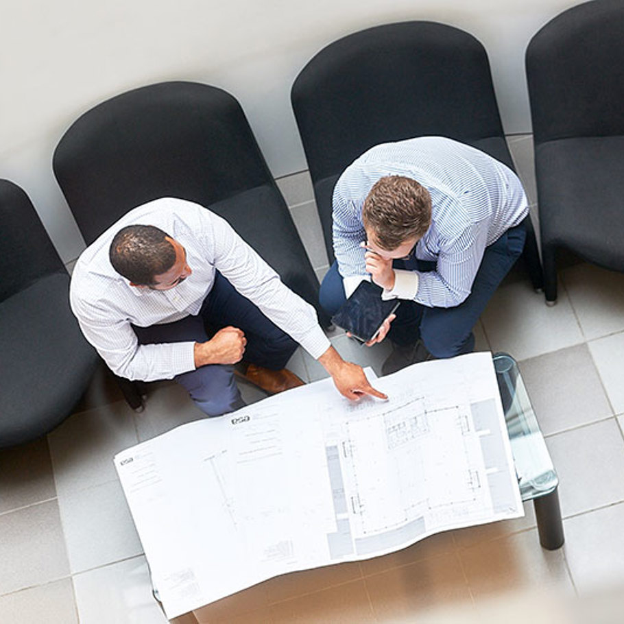 2 people reviewing a construction drawing 